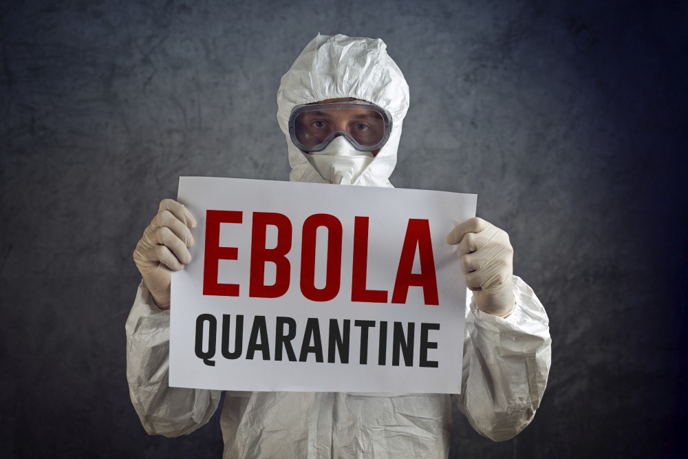 Ebola Quarantine sign held by medical healh care worker wearing protective gown, glowes, mask and goggles.