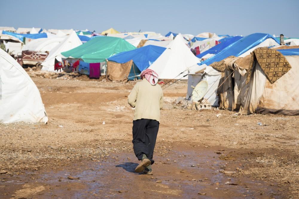 A Syrian refugee walks at the camp for internally displaced persons in Atmeh, Syria, adjacent to the Turkish border