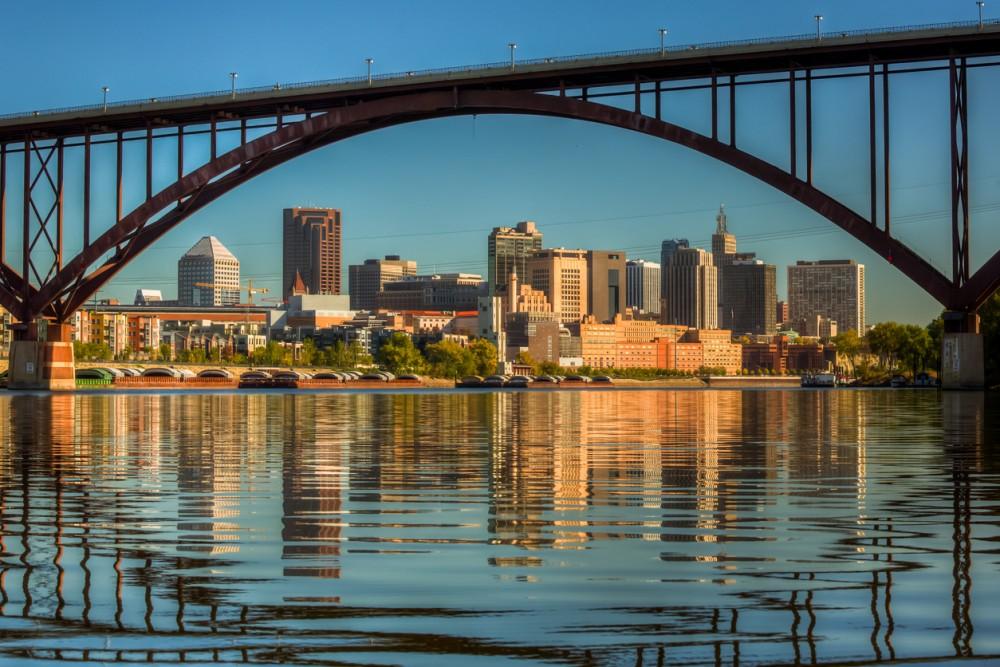 A view of downtown St. Paul in the morning with still water from the Mississippi River with reflection from the High Bridge.