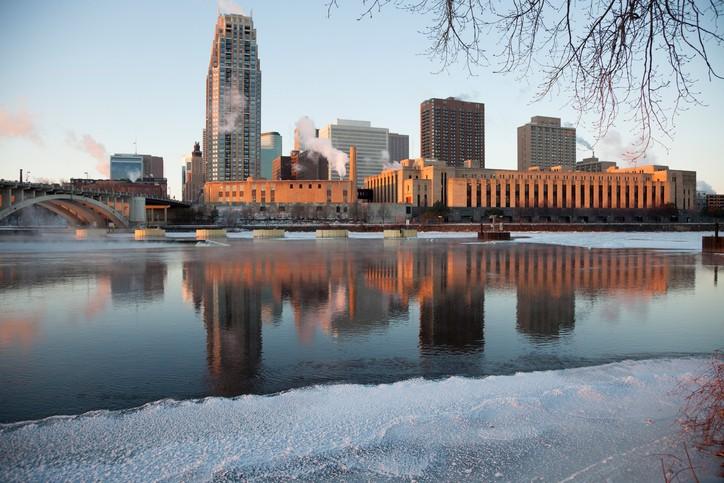 Downtown Minneapolis skyline across from the Mississippi River in the morning sun during the winter.