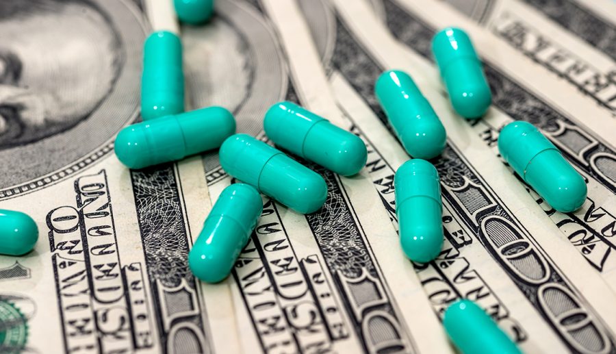 Medicines capsules on dollar bills close up